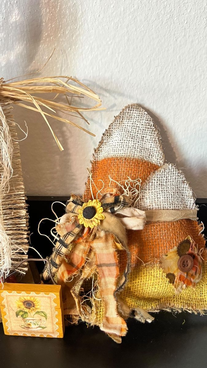 two scarecrows are sitting next to each other on a black table with an orange and white pumpkin