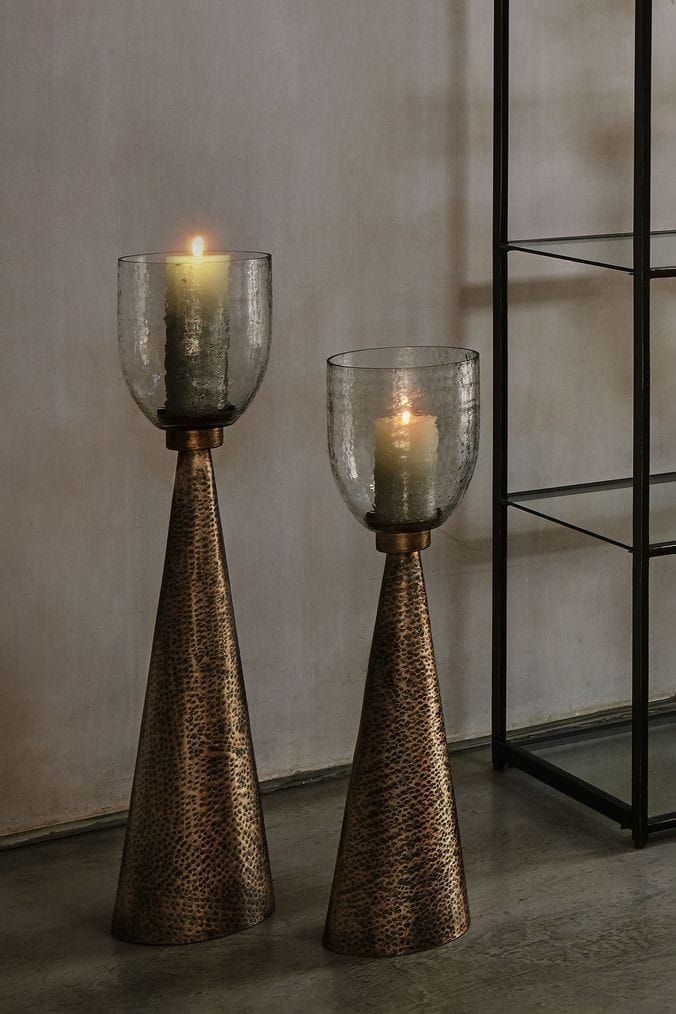 two candles sitting on top of metal cones