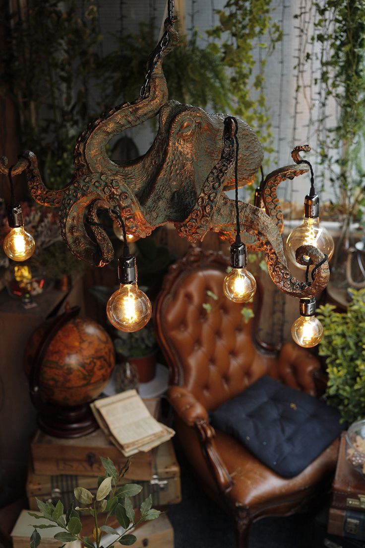 an old chair and some lights hanging from it's ceiling in a room filled with plants