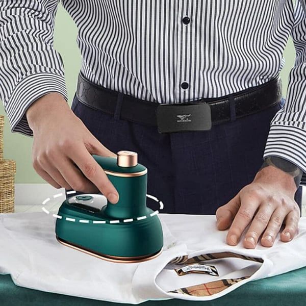 a man ironing clothes on an ironing board with a green hand held electric iron