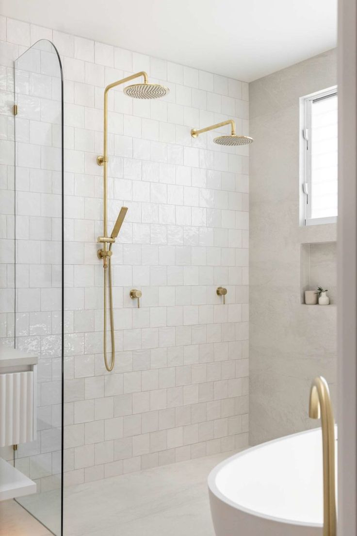 a bathroom with a tub, shower head and white tiled walls is shown in this image