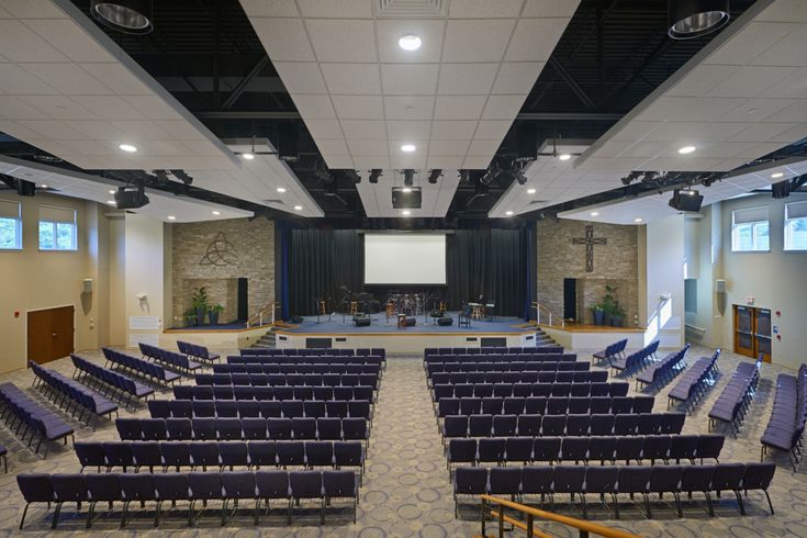 an empty room with rows of chairs and a projector screen