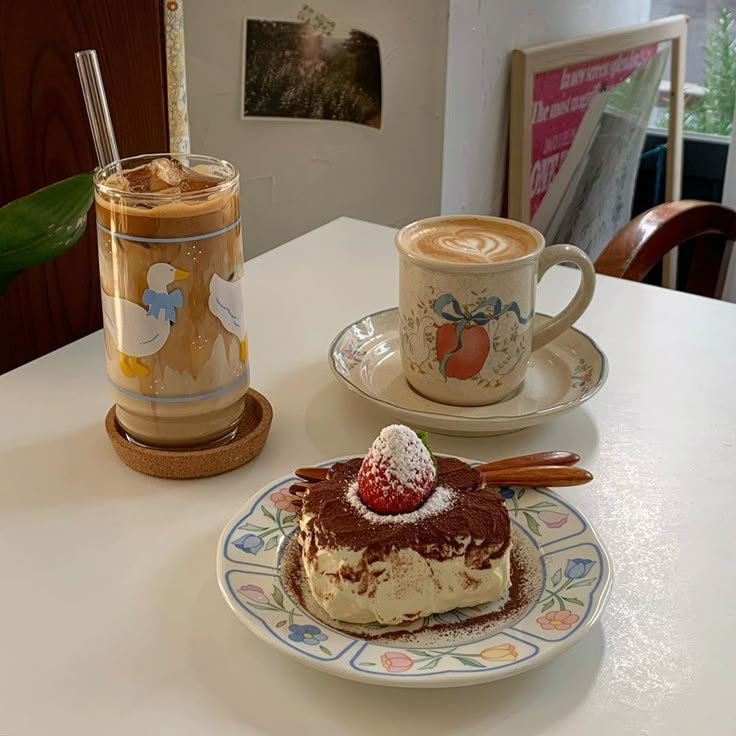 a piece of cake on a plate next to a cup of coffee