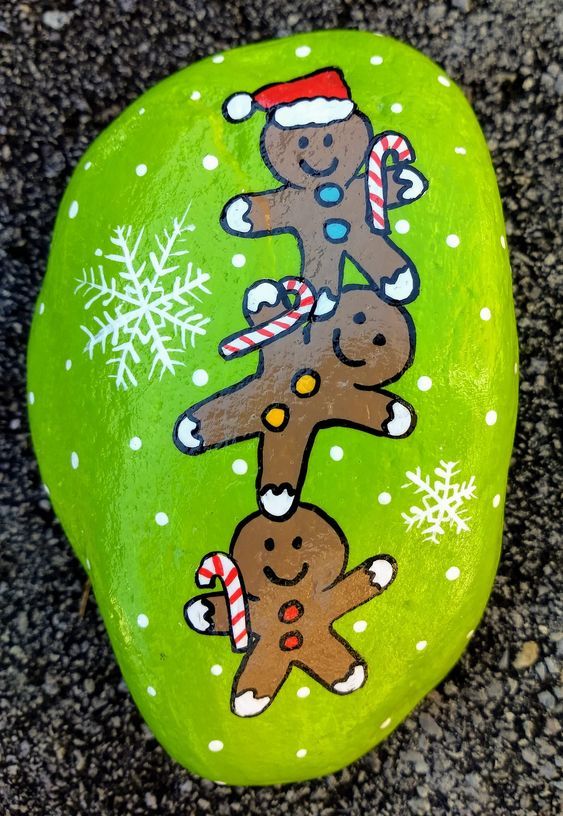 a painted rock with gingerbread men on it