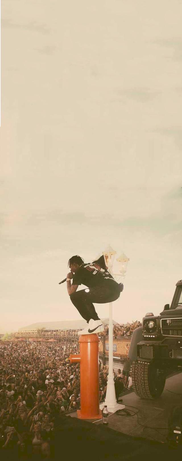 a person jumping over an orange object on top of a car in front of a crowd