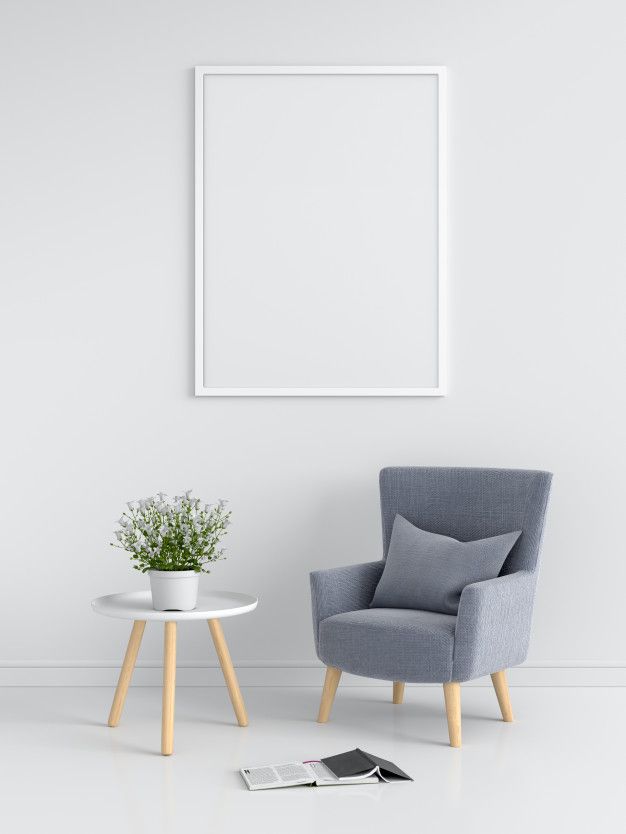 a chair and table in front of a white wall with a poster on the wall