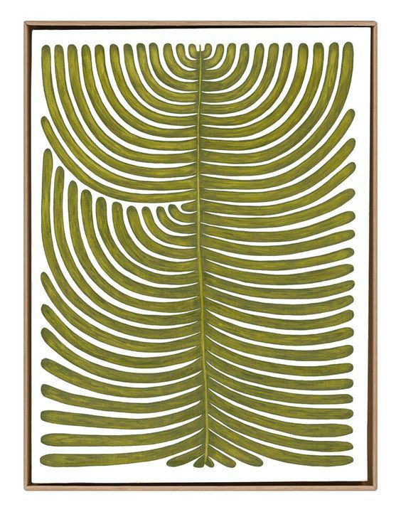 a green fern leaf in a wooden frame on a white wall with a gold border