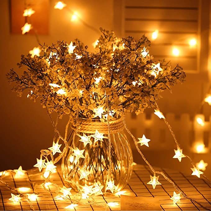 a vase filled with flowers and stars on top of a table