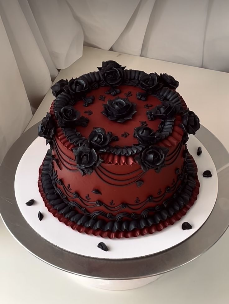 a red and black decorated cake sitting on top of a table