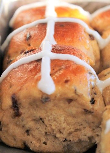 hot cross buns with icing on top in a baking pan, ready to be eaten