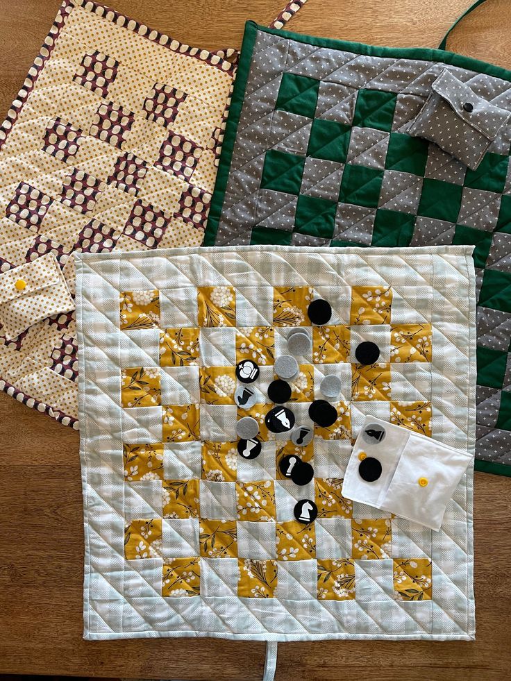 two quilts are sitting on the floor next to each other, one has buttons in it