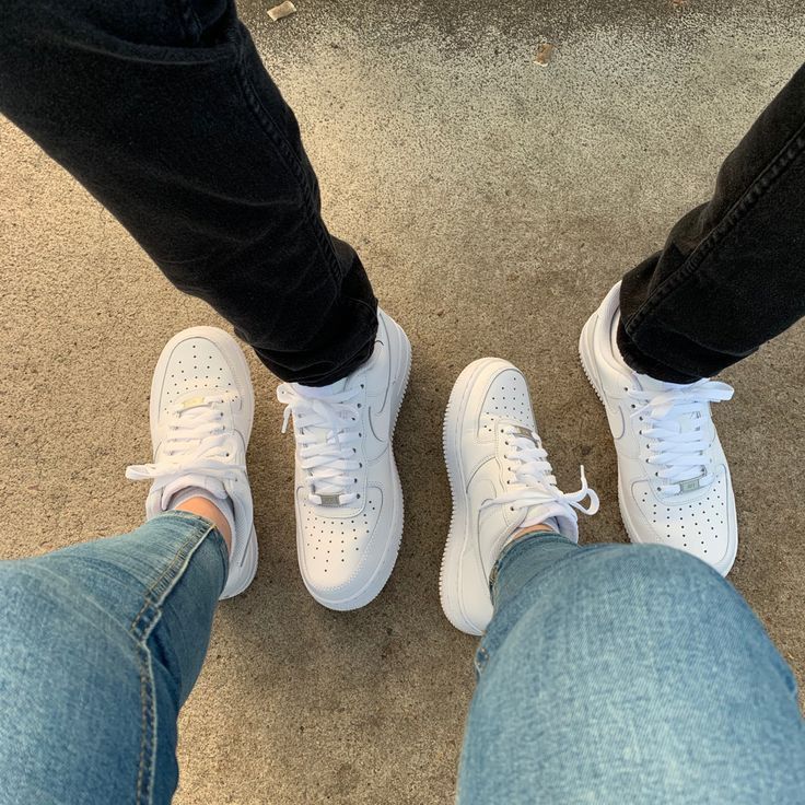 two people standing next to each other wearing white shoes