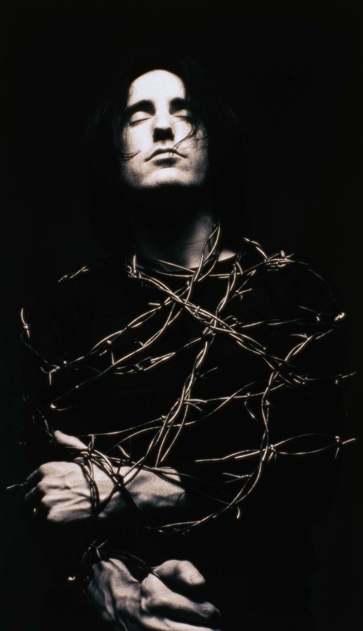 a man with his arms wrapped around barbed wire