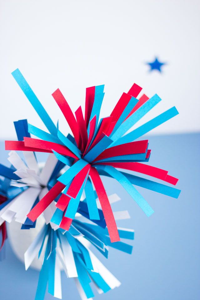 red, white and blue paper fireworks are in the air