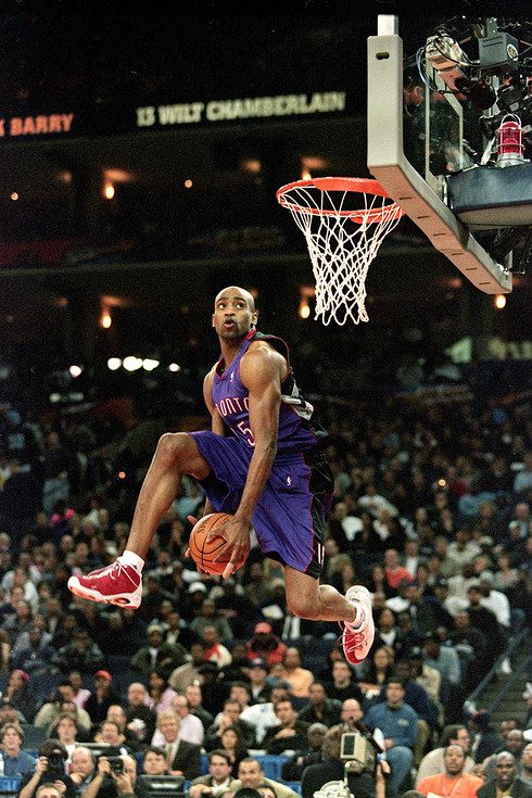 a basketball player dunking the ball in front of an audience