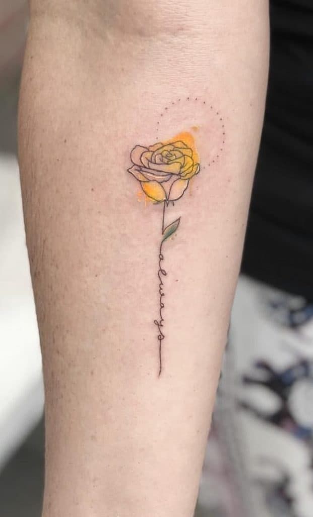 a small yellow rose tattoo on the leg