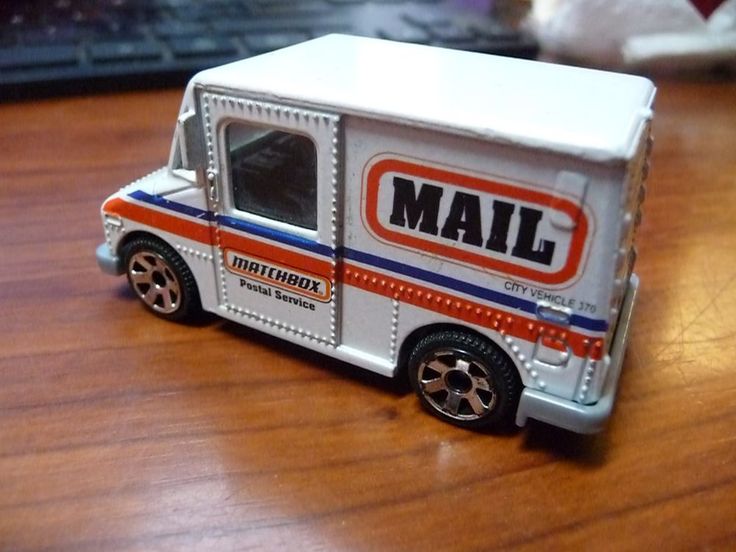 a close up of a toy truck on a wooden table with a computer in the background