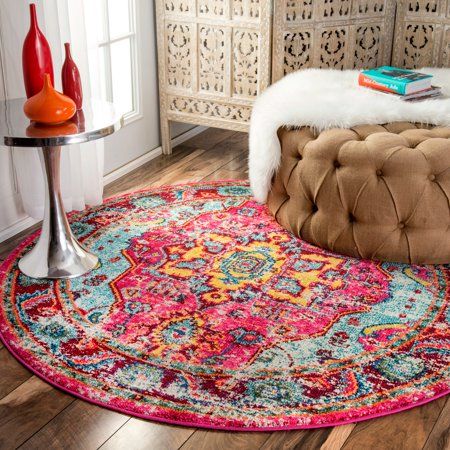 a round rug on the floor in a room with a table and two vases