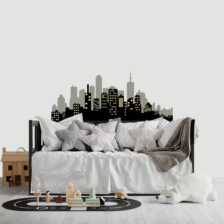 a living room with a couch and city skyline wall decal on the wall behind it