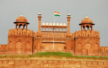 a large brick building with two towers and a flag on top