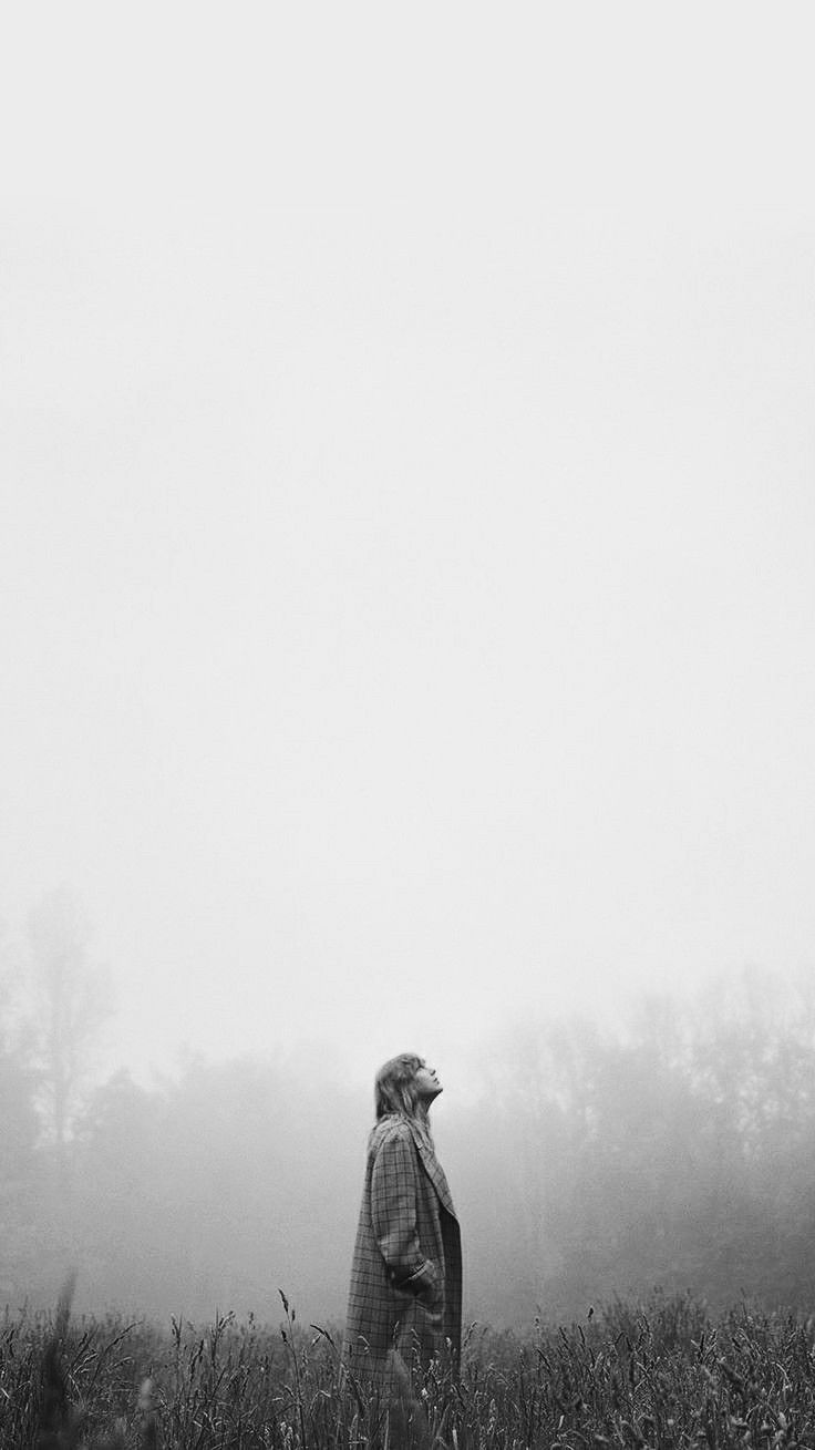 a person standing in a field on a foggy day