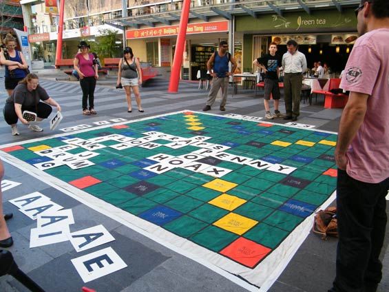 people are playing a game on the floor in an open area with tables and chairs