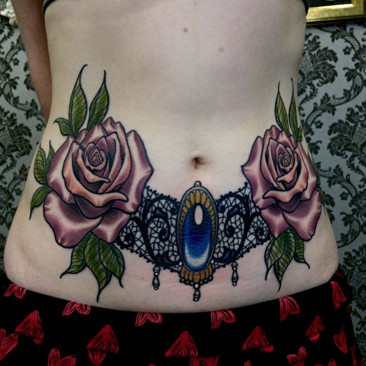 a woman's stomach with tattoos and roses on it