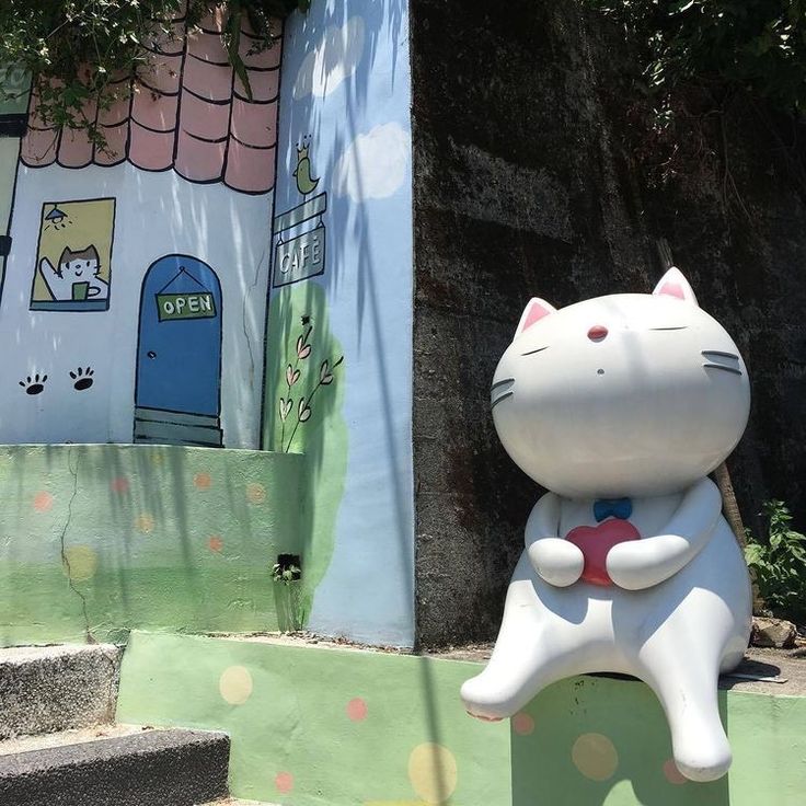 a statue of a cat sitting on top of some steps