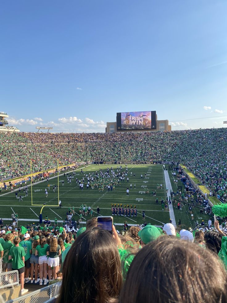 a football stadium filled with lots of green and white people standing on the sidelines