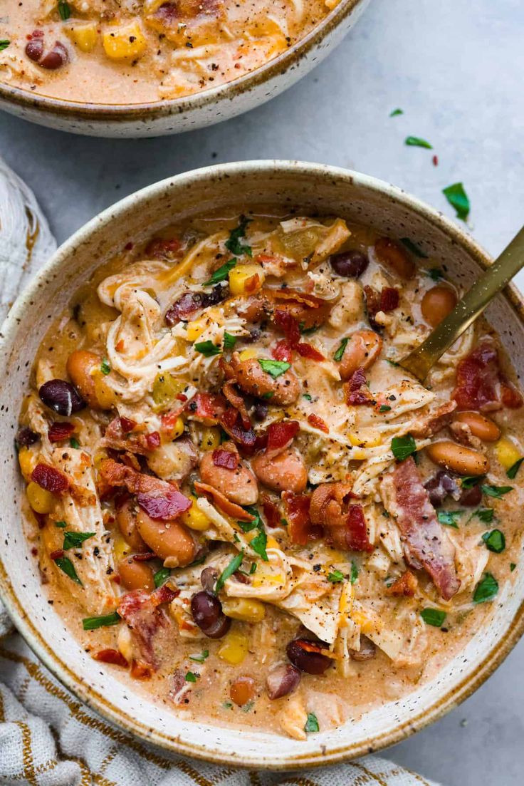 two bowls filled with chicken and bean soup