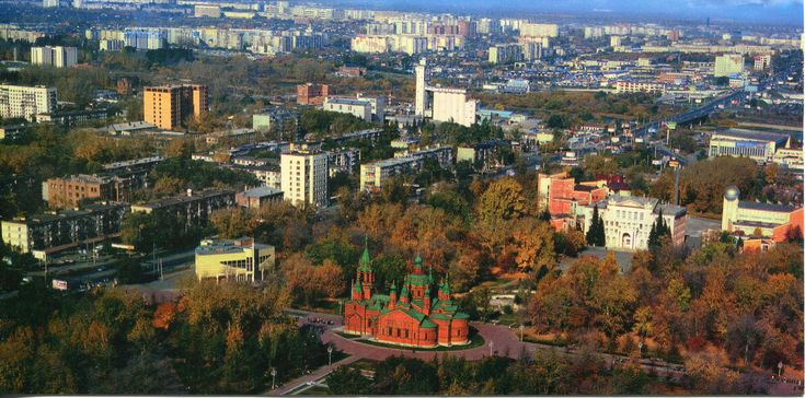 an aerial view of a city with tall buildings and trees in the foreground,