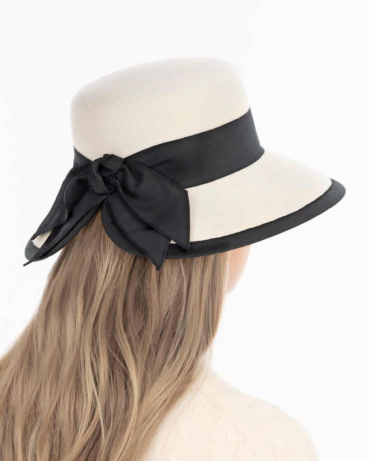 A women’s fall felt hat, trimmed with grosgrain that is timeless and chic. This is a special occasion style, not to be worn casually, which adds grace and presence. Viewed from the front, the dressy silhouette reminds one of Audrey Hepburn’s hats; a medium size brim curves gently downward .The unexpected surprise feature is the cutaway tulip shape of the brim in back, which finishes in a feminine double bow. UPF 50+ Blocks 98% UVA/UVB rays Hand blocked Elasticized inner band for comfortable fit Elegant Lined Hat With Curved Brim, Elegant Hat With Lined Curved Brim, Elegant Hat With Curved Brim And Lining, Classic Fur Felt Hat For Spring, Elegant Lined Hats For Spring, Elegant Beige Felt Hat For Fall, Chic Wide Brim Felt Hat For Kentucky Derby, Elegant Spring Hats With Lining, Elegant Fall Boater Hat With Brim