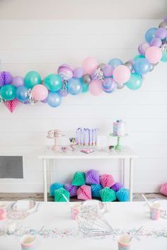 a birthday party with balloons, cake and cupcakes