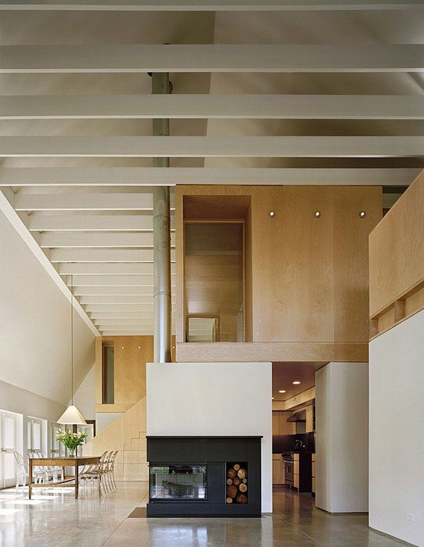 a living room with a fire place in the center and stairs leading up to it