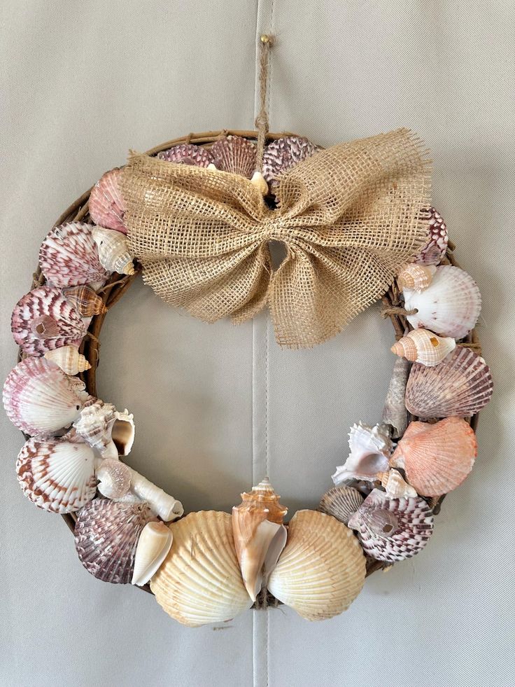 a wreath made out of seashells and burlocks hangs on the wall