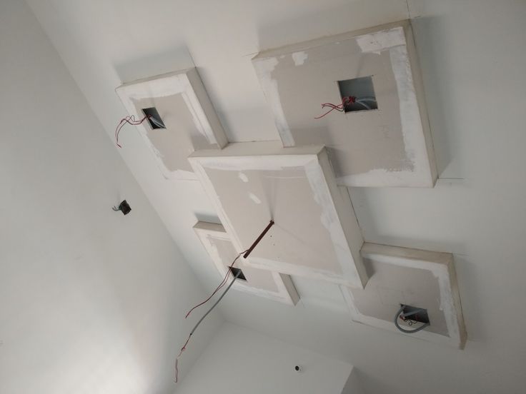 an unfinished room with some electrical wires attached to the wall and two square holes in the ceiling