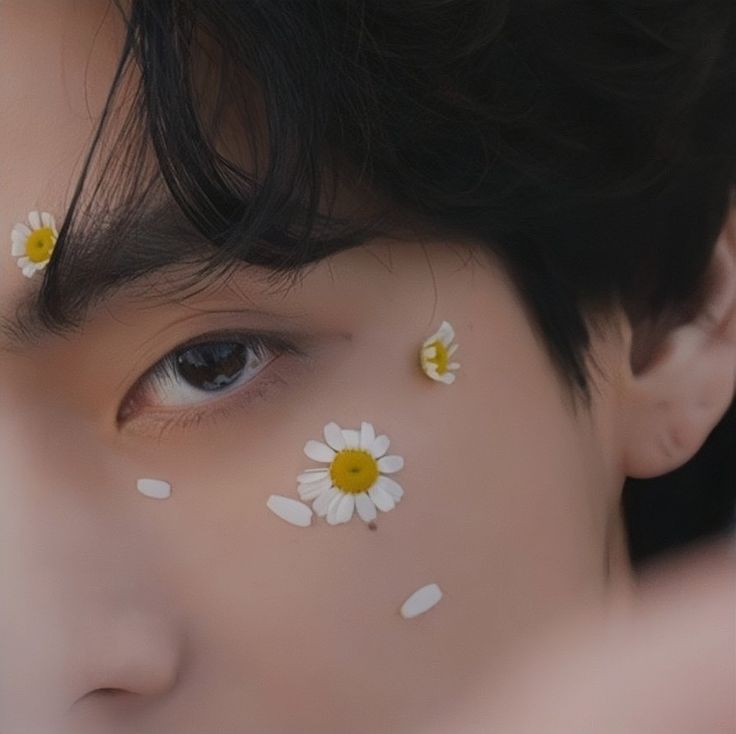 a close up of a child's face with flowers painted on their foreheads