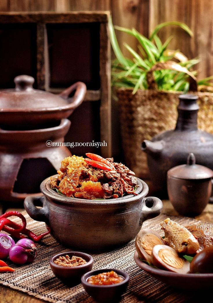 there is a bowl full of food on the table with other bowls and containers around it