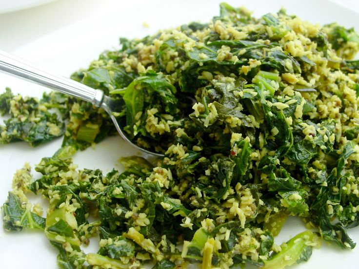 a white plate topped with broccoli covered in seasoning next to a spoon