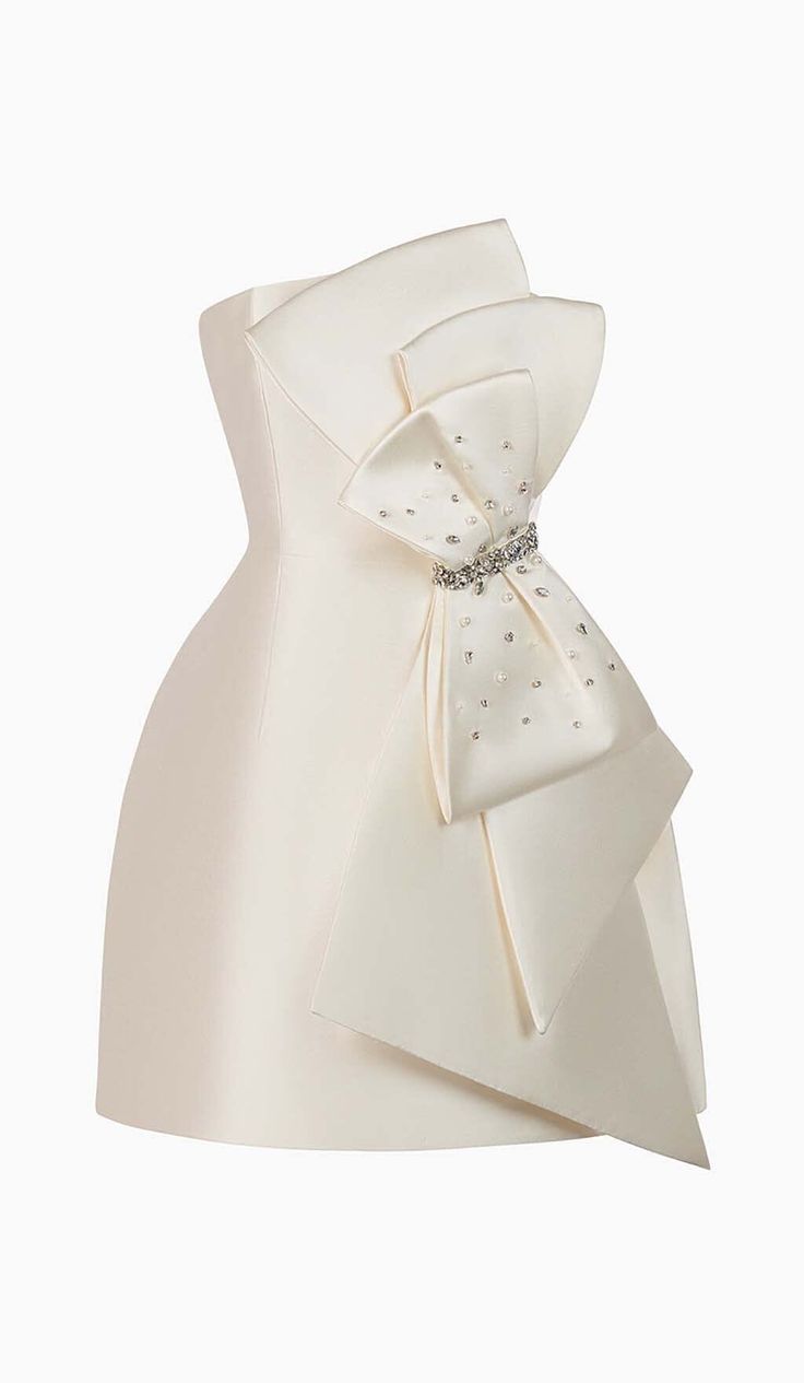 Strapless Bow Mini DressElevate your style and embrace your inner princess with our Strapless Bow Mini Dress. This stunning dress is designed to make you feel like royalty, featuring a playful oversized bow that cascades down the front, exuding a charming fairy tale vibe.The strapless neckline of this dress is designed to flatter your décolletage, adding an elegant touch to your overall look. The ivory color adds a touch of sophistication and grace, making it the perfect choice for any special o