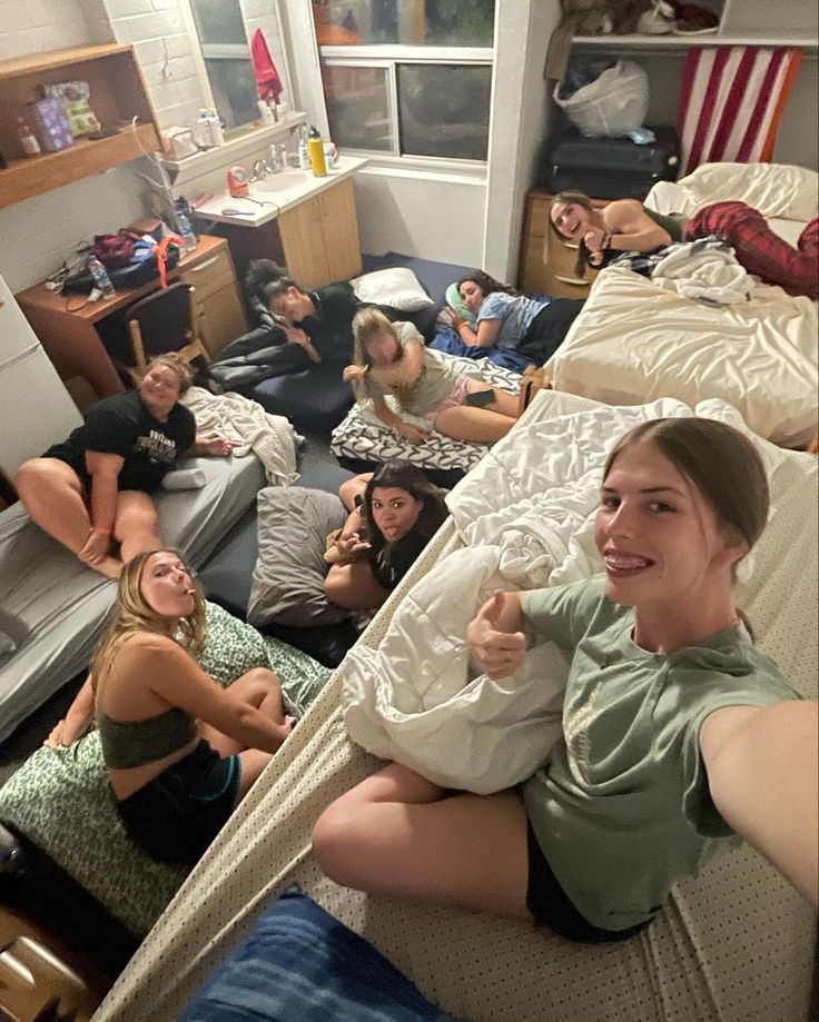 a group of people laying on top of a bed in a room next to each other