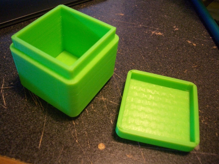 two green plastic containers sitting on top of a counter next to a black countertop