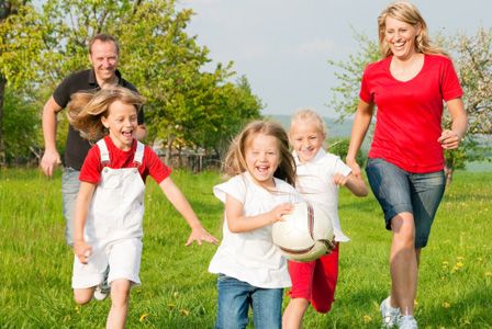 a group of people that are running in the grass with a frisbee and ball