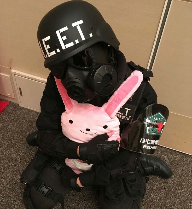 a person in a gas mask holding a stuffed animal and wearing a pink bunny costume