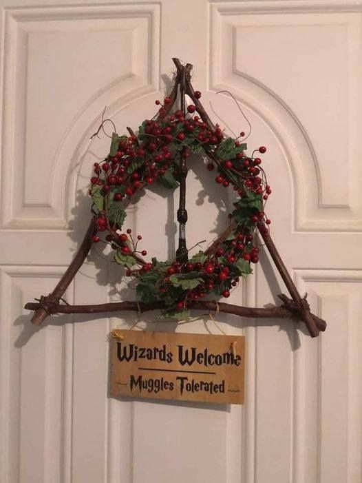 a wreath hanging on the front door of a building with a sign that says wizards welcome