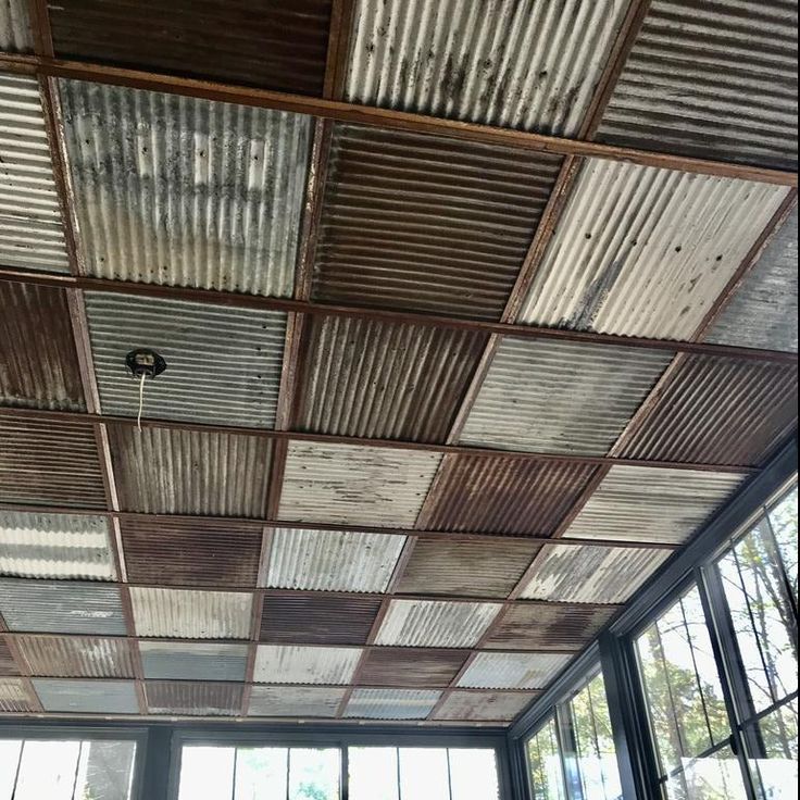 an old tin ceiling in a room with large windows and lots of wood planks