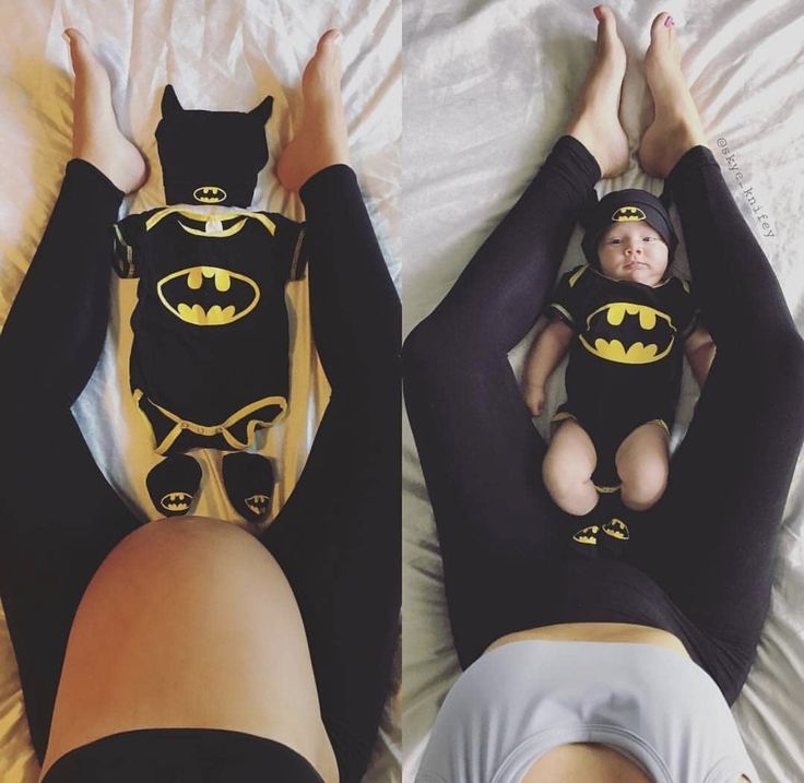 two women laying on top of a bed wearing batman shirts and black leggings