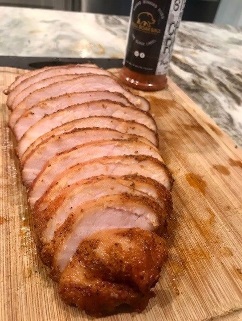 sliced pork sitting on top of a wooden cutting board