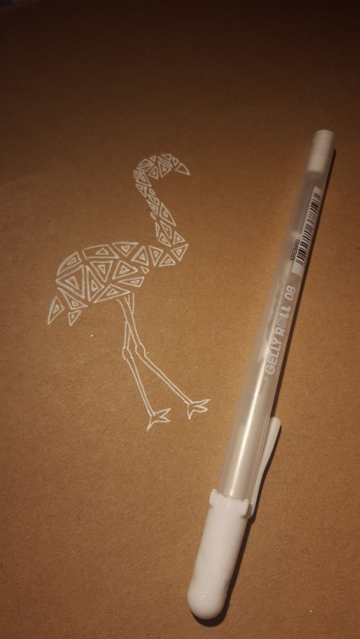 a pen sitting on top of a piece of paper next to a drawing of an ostrich