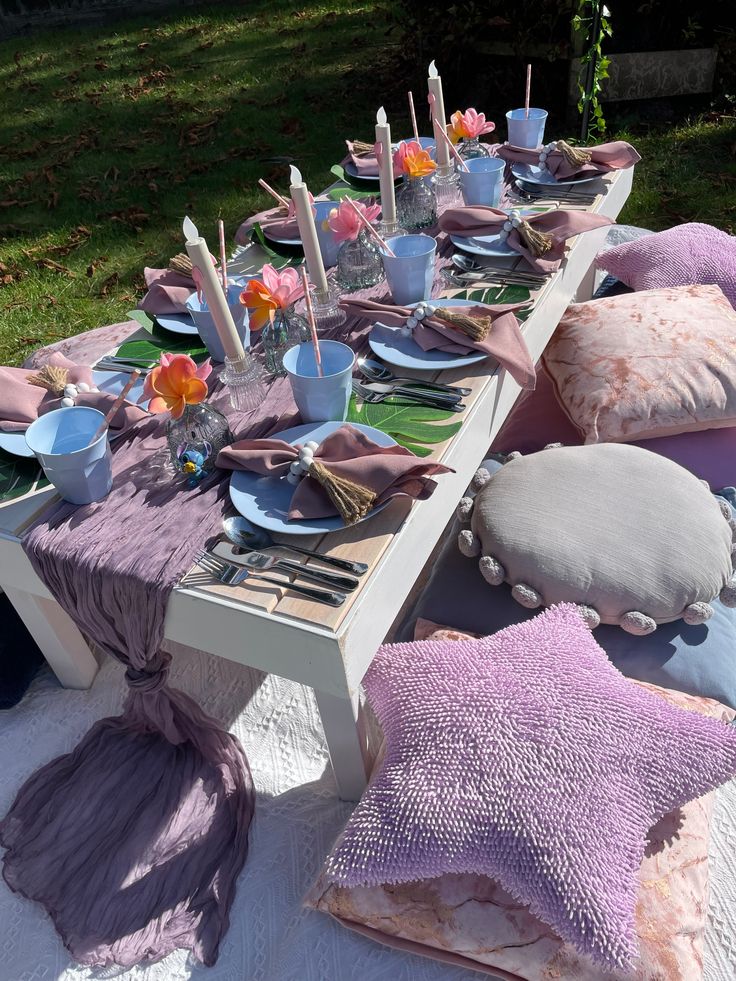 the table is set with purple and pink pillows